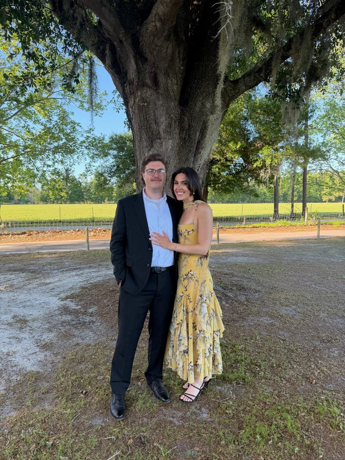 Haley and Slade embracing under a sprawling oak tree
